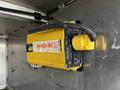 A yellow power inverter mounted on a metallic surface with various wires connected to it