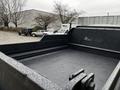 A 2005 GMC C5 Duramax truck bed with a textured black surface and a metal mesh vent on one side