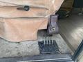 Close-up of the control panel for hydraulic leveling with four vertical levers and a brown leather pouch attached to the side of a beige seat in a vintage Chevrolet Fleetwood Pace Arrow
