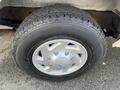 Close-up of a gray wheel from a 2008 Ford Econoline featuring a five-spoke silver rim and a black tire with tread patterns