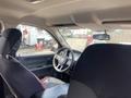 The interior of a 2012 RAM 2500 with a driver's seat covered in a black seat cover and a steering wheel visible