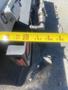 A measuring tape extended across the edge of a 2012 International 7400 truck body showing the rear taillight and part of the truck’s hardware