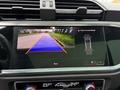 A 2024 Audi Q3's display screen showing a rearview camera image with guidelines indicating the parking space and vehicle position