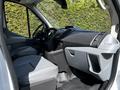 Interior view of a 2015 Ford Transit showcasing the driver’s seat dashboard and central console with gray seating and storage compartments