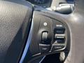 Close-up of the steering wheel controls in a 2017 Acura TLX including buttons for information main resume trip and cancel