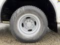 A close-up of the wheel of a 2012 Ford Econoline featuring a silver rim and a rugged tire with visible wear marks