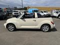 A 2005 Chrysler PT Cruiser convertible in cream color with a black interior parked with the top down