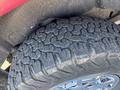 Close-up of a rugged tire with deep treads mounted on a rim showing a shiny finish
