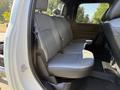 The interior of a 2022 RAM 5500 featuring a gray leather rear bench seat with seat belts and a textured floor mat