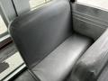 Interior seat of a 2015 Spartan School Bus featuring a grey vinyl covering with a simple design and an unobstructed view of the adjacent side of the bus