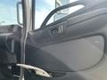 Interior door panel of a 2018 Hino 338 showing the handle and storage compartment with a visible magazine inside