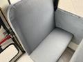 A gray vinyl seat in a vehicle with a simple rectangular shape and an upright backrest