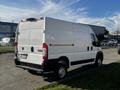 A white 2021 RAM Promaster van is parked with a high roof and rear doors slightly ajar showcasing a spacious cargo area