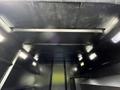 Interior view of a 2012 Freightliner M2 106 with black walls and ceiling featuring lights and structural supports