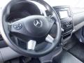The interior of a 2016 Mercedes-Benz Sprinter featuring a steering wheel with controls and a dashboard display