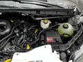 The image shows the engine compartment of a 2023 Ford Transit with visible components including hoses battery and coolant reservoir