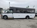 A 2017 Chevrolet Express with a white and black exterior designed as a shuttle bus featuring large side windows and a flat front