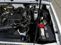 Engine compartment of a 2010 Ford Ranger featuring a black engine cover battery and various components including hoses and a coolant reservoir