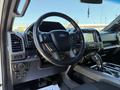 Interior view of a 2018 Ford F-150 featuring a black steering wheel with controls a touchscreen display and a modern dashboard design