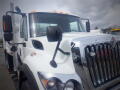 A 2016 International 7400 truck with a white exterior and chrome grille featuring large headlights and side mirrors