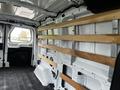 Interior view of a 2023 Ford Transit van featuring wooden shelving installed along the walls for storage and cargo organization