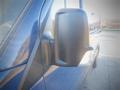 A side mirror of a blue 2017 Mercedes-Benz Sprinter van