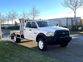 A 2014 RAM 5500 flatbed truck with a white body and black front grille parked on a street