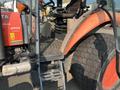 2014 Kubota M7060 tractor featuring a red and gray exterior with large rear tires and a spacious operator station with controls and a seat