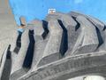 Close-up of a large, rugged tire from a 1997 Genie S-65 4X4 featuring deep treads and a sturdy build designed for off-road use