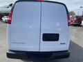 A 2022 GMC Savana van viewed from the rear showing its white exterior and rear doors without a license plate