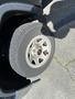A silver wheel with a GMC emblem and a black tire mounted on it