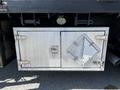 A metallic storage compartment on a 2012 Freightliner M2 112 truck with a diamond-shaped lock and a single latch on the door