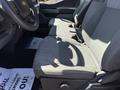 Interior view of a 2023 Ford F-550 showing gray fabric front seats with center console and seatbelts attached