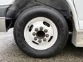 A close-up view of a white wheel with a General Grabber tire mounted on it showcasing the lug nuts and wheel design