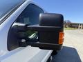 Close-up of the side mirror of a 2014 Ford F-250 SD featuring orange indicator light and a black housing