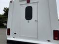 A 2014 Ford E-350 van with a white exterior featuring a rear door and a wheelchair accessibility sign mounted on it