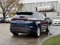 A blue 2017 Ford Edge parked with its back facing the viewer showcasing a sleek design and modern taillights