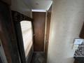 A 2013 Outdoor Wind River trailer interior featuring a narrow hallway with a door at the end and a window covered by a beige shade