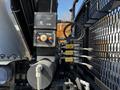 A detailed view of the control panel and hydraulic implements of a 2012 Freightliner M2 112 truck showcasing levers and switches