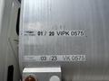 A metallic surface with a series of labels and numbers including 25 668 01 20 VIPK 0575 03 23 VK 0575 and a contact number 250 785 8642