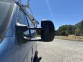 A side view of a blue 2008 Ford E-350 van with a prominent side mirror visible in the foreground