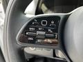 Close-up of a steering wheel control panel featuring buttons for cruise control and settings on a 2023 Mercedes-Benz Sprinter