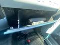 Interior view of the glove compartment in a 2016 Ford F-350 SD with an open lid and some items visible inside