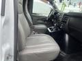 Interior of a 2016 Chevrolet Express showing two gray leather seats and the dashboard with control panel and gear shifter