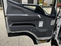 A driver's side door panel of a 2015 Mitsubishi Fuso FE featuring a gray interior with a handle and control buttons