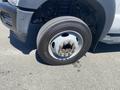 A 2015 Ford F-450 SD with a silver rim and a tire showing wear and visible lug nuts