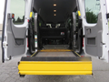 A 2009 Dodge Sprinter Van with open rear doors showing a yellow wheelchair ramp and seats inside the cargo area