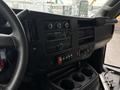 Interior dashboard of a 2020 Chevrolet Express showing climate control knobs a radio display and various buttons with cup holders below