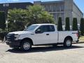 A white 2016 Ford F-150 with a standard cab and four-wheel drive parked on a paved surface