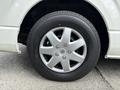 A silver alloy wheel with five spokes mounted on a black Bridgestone tire on a 2009 Toyota Hiace